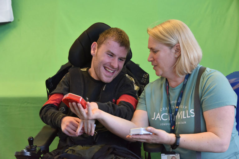 person in a wheelchair talking to carer