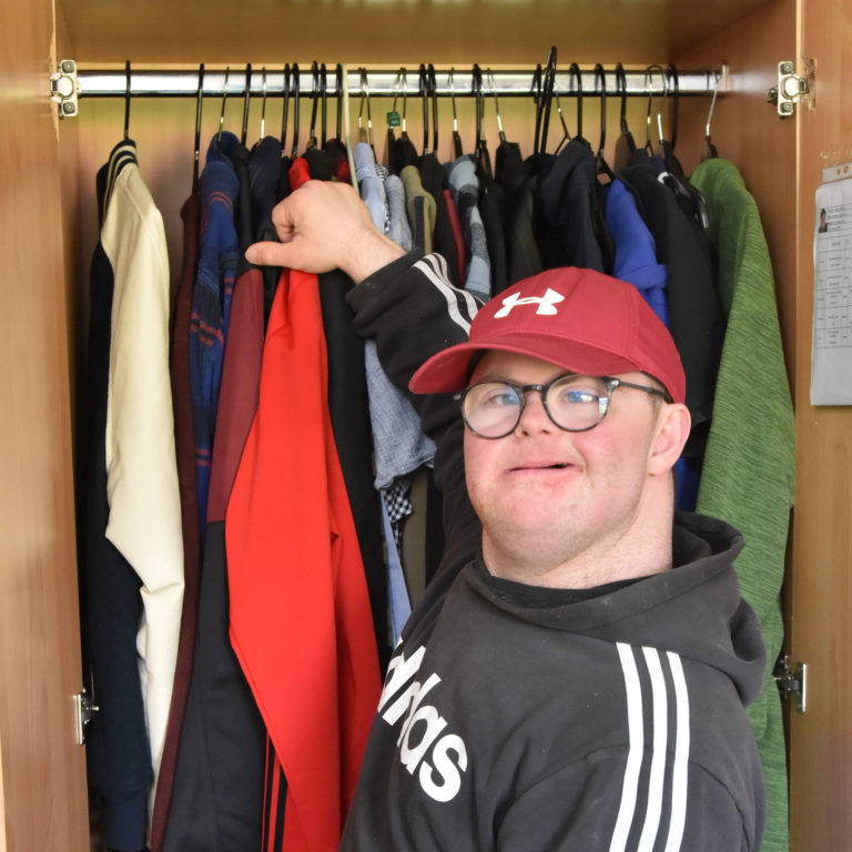 person taking clothes out of a wardrobe