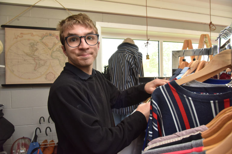 student sorting clothes in the charity shop