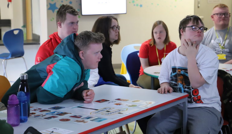 Students sat leaning on a table listening to a Money Matters workshop